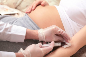 Quad-screen-pregnant-woman-nurse-taking-blood-syringe | American Pregnancy Association