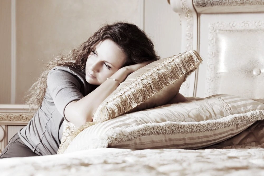 woman-resting-head-on-pillows-after-miscarriage | American Pregnancy Association