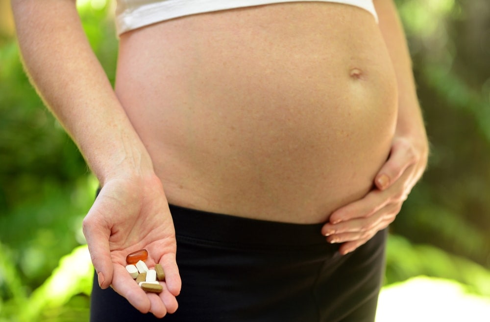 Madre embarazada que toma las vitaminas prenatales